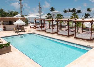 - une piscine avec des chaises et un parasol dans un complexe dans l'établissement Parguera Plaza Hotel - Adults Only, à La Parguera