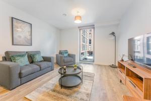 a living room with a couch and a tv at Central Birmingham 1 Bedroom Apartment in Birmingham