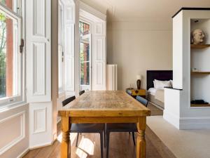 uma sala de jantar com uma mesa de madeira e um quarto em Pass the Keys Sophisticated Studio in South Kensington em Londres
