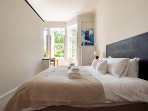 a bedroom with a large bed with towels on it at Pass the Keys Gorgeous studio with access to a private garden in London