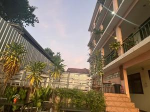 ein Apartmenthaus mit Palmen und einer Treppe in der Unterkunft โรงแรม พรรณทวี in Nong Khai