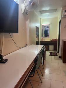 Zimmer mit einem Tisch und einem TV an der Wand in der Unterkunft โรงแรม พรรณทวี in Nong Khai