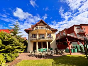a house with chairs and tables in front of it at Villa Amber in Międzywodzie