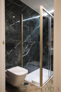 a bathroom with a toilet and a glass shower at Cool&Modern Apt para 4pax en el centro de Sevilla in Seville