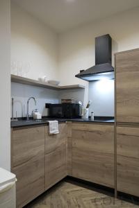 a kitchen with wooden cabinets and a sink and a stove at Cool&Modern Apt para 4pax en el centro de Sevilla in Seville