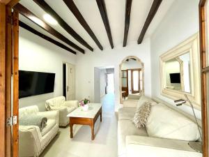 a living room with white furniture and a flat screen tv at Can Raixa in Lloseta