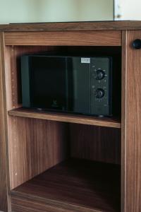 a microwave sitting inside of a wooden cabinet at JOST Auberge de jeunesse Montpellier Centre St Roch in Montpellier