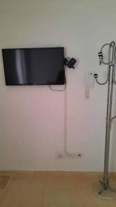 een flatscreen-tv aan een witte muur bij Monastir: superbe appartement neuf (2020) in Monastir