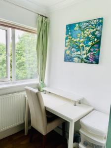 a white desk with a chair next to a window at Modern and chic rooms with beautiful landscape views in Sydenham