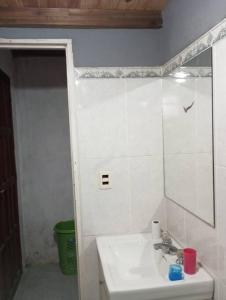 uma casa de banho branca com um lavatório e um espelho em Lo de Mora em Costa Azul