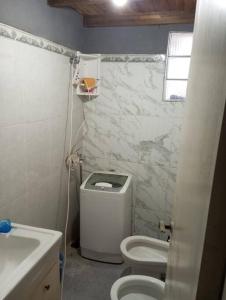 uma casa de banho branca com um WC e um lavatório em Lo de Mora em Costa Azul