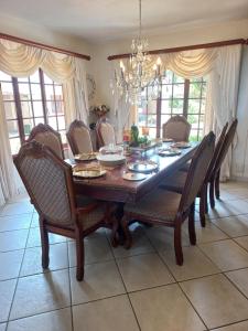 a dining room with a wooden table and chairs at Forest Dream House in Kloof