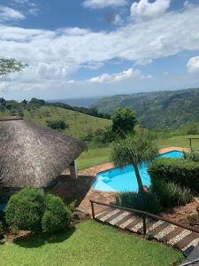 a resort with a swimming pool and a thatch roof at Forest Dream House in Kloof