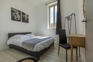 - une chambre avec un lit, un bureau et une chaise dans l'établissement LE SICRE - T3 confort, centre Castelsarrasin, parking, à Castelsarrasin