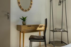 a desk with a chair next to a wall at LE SICRE - T3 confort, centre Castelsarrasin, parking in Castelsarrasin