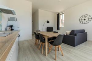 a kitchen and dining room with a wooden table and chairs at LE SICRE - T3 confort, centre Castelsarrasin, parking in Castelsarrasin