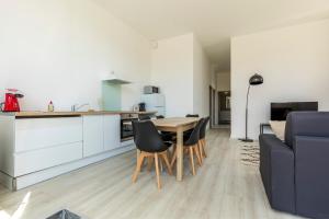 cocina y sala de estar con mesa y sillas en LE SICRE - T3 confort, centre Castelsarrasin, parking en Castelsarrasin