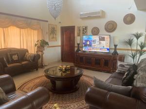 a living room with a couch and a television at Forest Dream House in Kloof