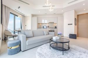 un salon avec un canapé et une table dans l'établissement STAY BY LATINEM Luxury 2BR Holiday Home W1504 near Burj Khalifa, à Dubaï