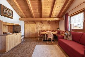 sala de estar con sofá rojo y mesa en Apartment Ruiel, en Santa Cristina Valgardena