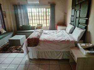 um quarto com uma cama grande e uma janela em GREEN TREE em Mtubatuba