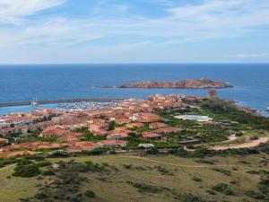 una vista aerea di un resort su un'isola nell'oceano di Residence Le Rocce Rosse a Isola Rossa