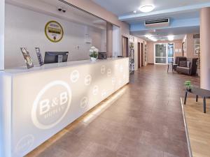 a lobby of a dental office with a reception counter at B&B Hotel Köln-Airport in Cologne