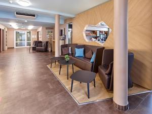 a lobby with a couch and chairs and tables at B&B Hotel Köln-Airport in Cologne