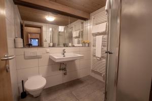 ein weißes Bad mit einem WC und einem Waschbecken in der Unterkunft Lake and Mountain View in Zell am See