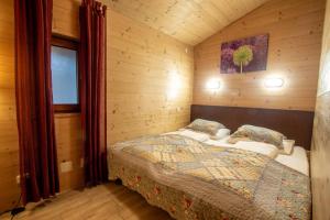 ein Schlafzimmer mit einem Bett in einer Holzhütte in der Unterkunft Lake and Mountain View in Zell am See