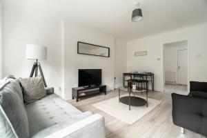 a living room with a couch and a flat screen tv at Glenisla House in Glasgow