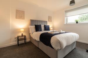 um quarto com uma cama grande e uma janela em Glenisla House em Glasgow