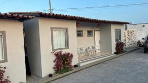 a house with chairs and flowers on the side of it at Pousada Oásis das Dunas in Santo Amaro