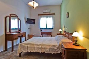 1 dormitorio con cama, escritorio y espejo en Villa Ntora, en Afiartis