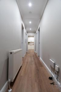 an empty hallway with white walls and wood floors at Shaw Apartment in Glasgow