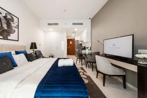 a living room with a large bed and a tv at Cozy studio at DamacHills2 in Dubai