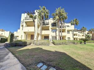 a large building with palm trees in front of it at Roda Golf Bali Apartment - 2610 in Roda