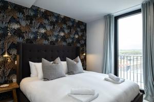 a bedroom with a large bed with a large window at Apartments in Hayle in Hayle