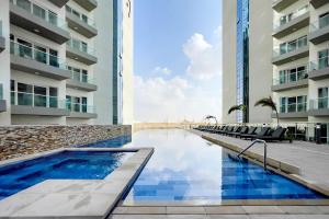 una piscina en medio de un edificio en Cozy studio at DamacHills2 en Dubái