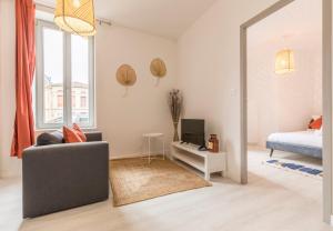 a living room with a couch and a mirror at LE CORAIL - 1 chambre, idéal couple, parking, 10min Canal du Midi in Castelsarrasin