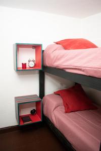 sypialnia z 2 łóżkami piętrowymi z zegarem i szafką nocną w obiekcie Habitaciones Temporarias CABA w BuenosAires