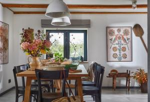 a dining room with a wooden table and chairs at Dobre Historie in Leśna