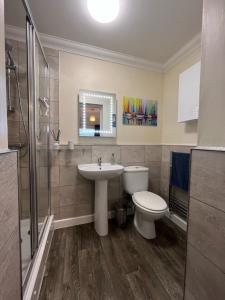 a bathroom with a sink toilet and a mirror at Rockmount Court in Bournemouth