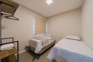 a room with two beds and a mirror in it at 603 MORSE MUITO CONFORTO PARA SUA FAMILA in Joinville