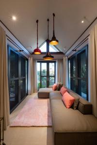 ein Wohnzimmer mit 2 Sofas und großen Fenstern in der Unterkunft Entire Luxury Private Pool Villa No.8 Chiang Mai in Chiang Mai