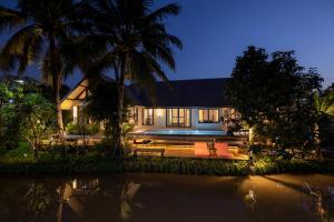 ein Haus mit einer Bank und Palmen in der Nacht in der Unterkunft Entire Luxury Private Pool Villa No.8 Chiang Mai in Chiang Mai