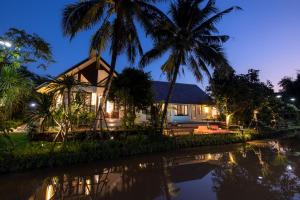 ein Haus mit Palmen davor in der Unterkunft Entire Luxury Private Pool Villa No.8 Chiang Mai in Chiang Mai