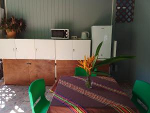 une salle à manger avec une table et des chaises vertes dans l'établissement Fare Mihimana, à Vaïare
