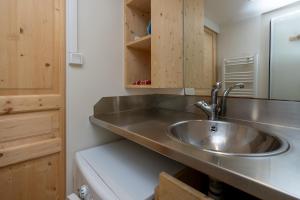 a kitchen with a stainless steel sink and a mirror at Les chats perchés 400m plage G in Labenne +22 photos