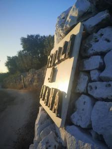 a sign on the side of a stone wall at Trulli di Ivana in Ostuni